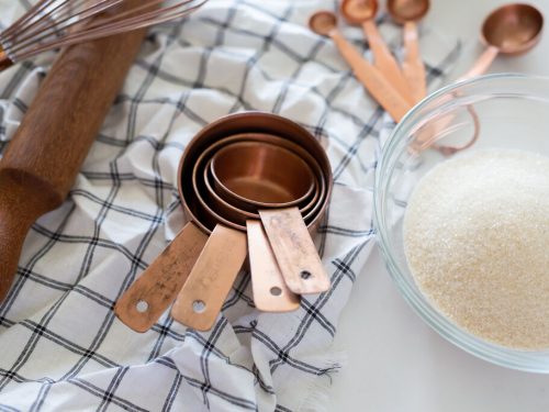 measuring cups and a bowl of sugar