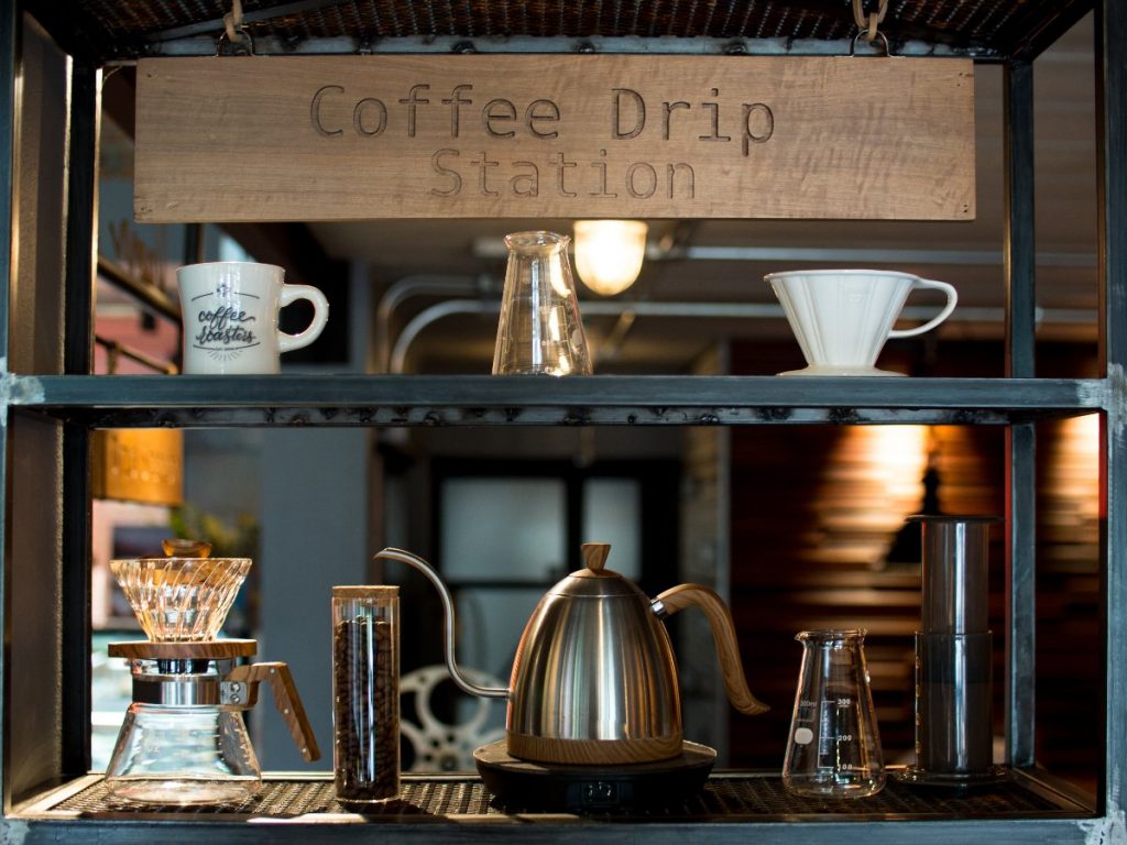 Coffee bar ideas with metal gooseneck kettle, canister of ground coffee, and drip coffee equipment