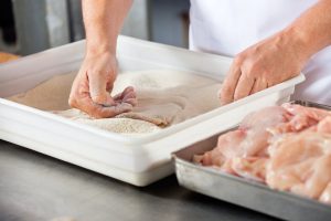 dredging chicken meat in the flour