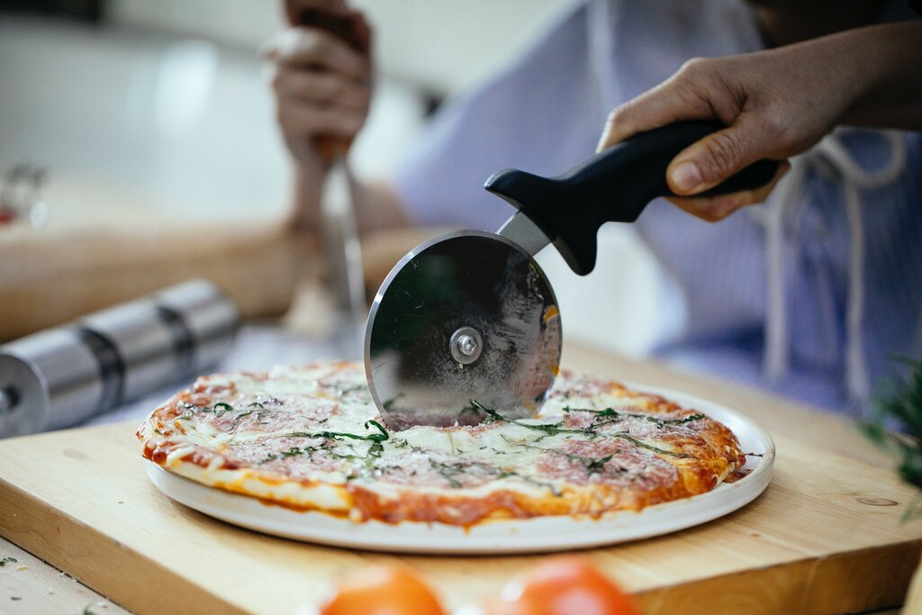 slicing pizza with pizza cutter