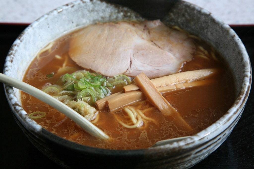 Bowl of Asahikawa ramen, topped with chashu, chopped scallions, and fermented bamboo shoots