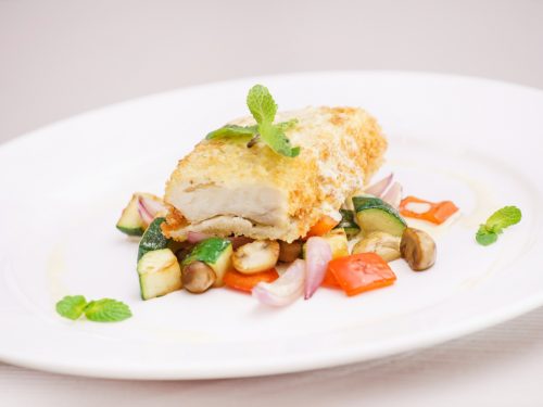 Black Sea Bass Recipe, Pan-fried and roasted black sea bass served over vegetables on a white plate