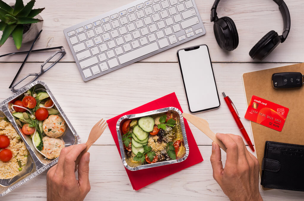 Person with a bowl of salad on a work desk for easy weeknight dinners