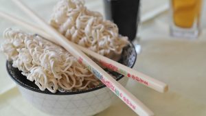 Instant noodles on a bowl with wooden chopsticks 