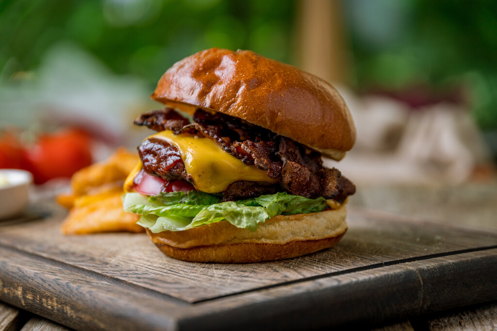 travis scott burger with meat, cheese and bacon on the board