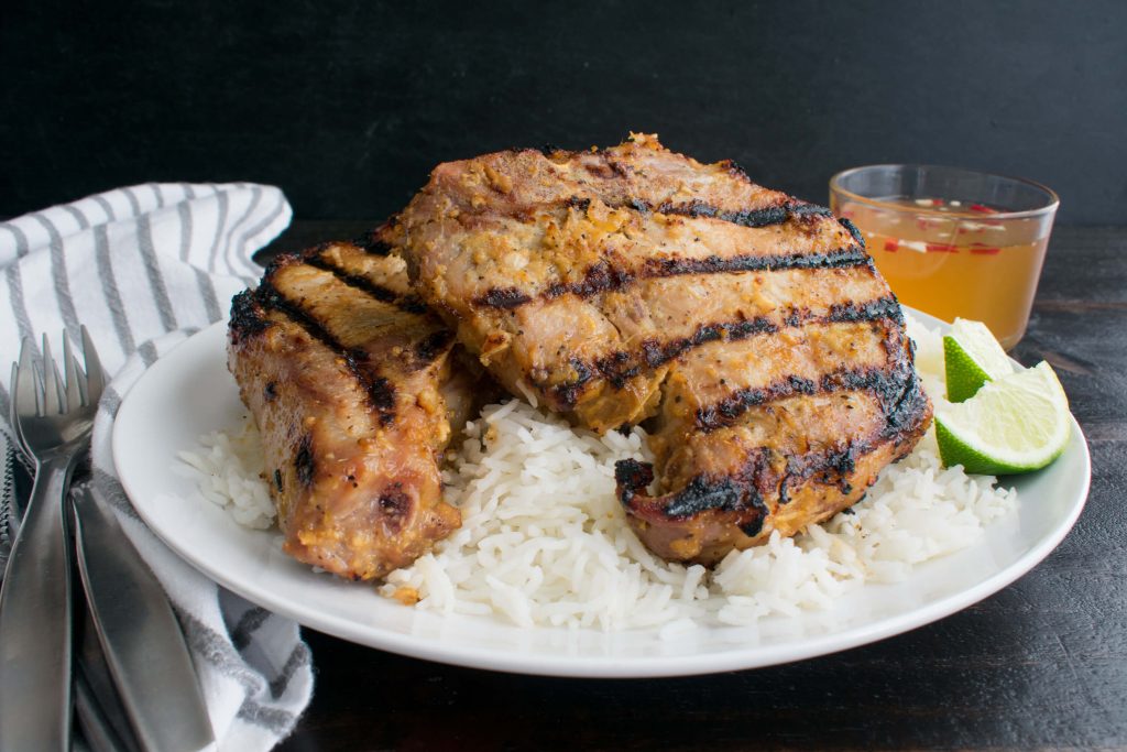 vietnamese pork chops on a bed of rice with lemon and nuoc cham