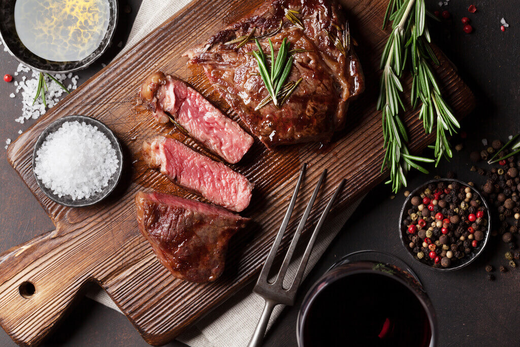 steak cut on chopping board, grilled ribeye, best cut of steak