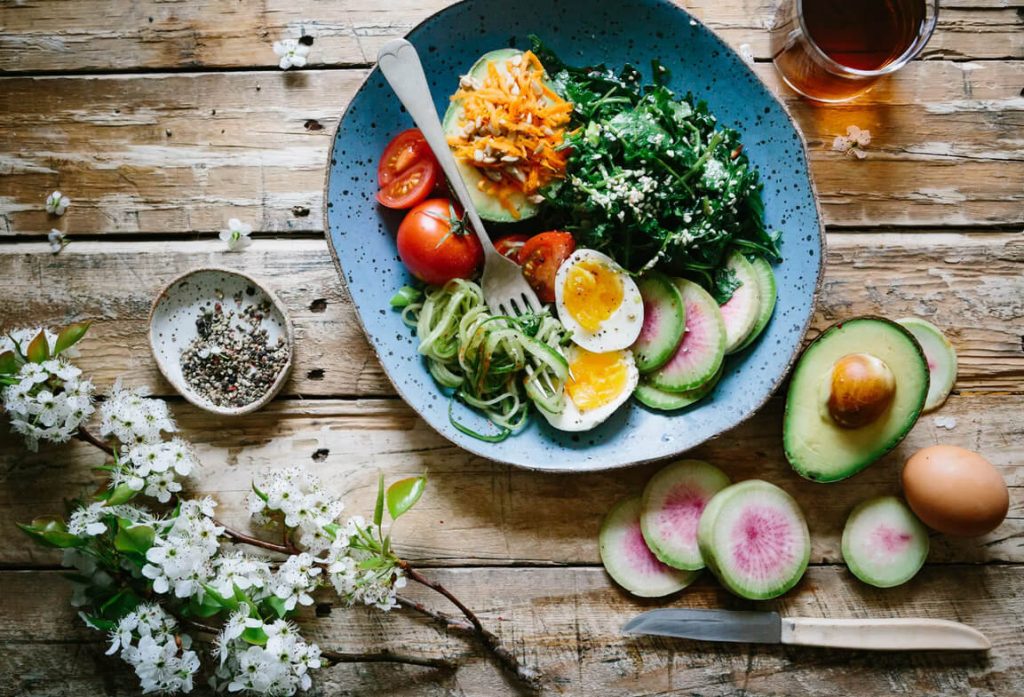 Top view of keto-friendly salad, eggs, tomato, avocado, and cheese