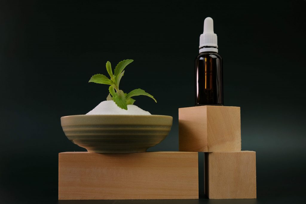 Powder stevia and liquid stevia placed over wooden blocks