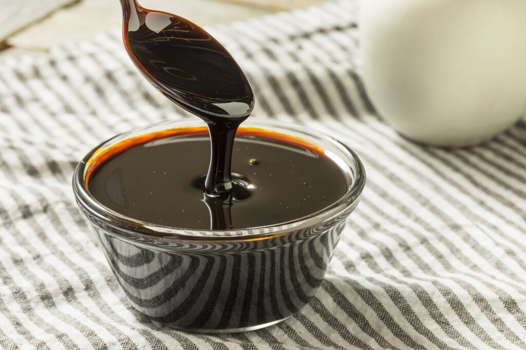 Organic black cane sugar molasses in a bowl, honey substitute