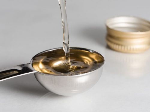 pouring white wine vinegar on a tablespoon