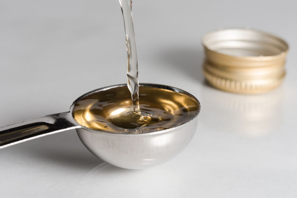 pouring white wine vinegar on a tablespoon