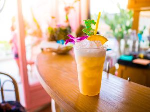 Hawaiian mango rum cocktail on a bar with decorative straw.