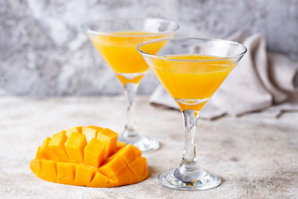 A simple mango cocktail in a martini glass.