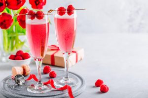 ink cocktail with champagne or prosecco and fresh raspberries for Valentine's day.