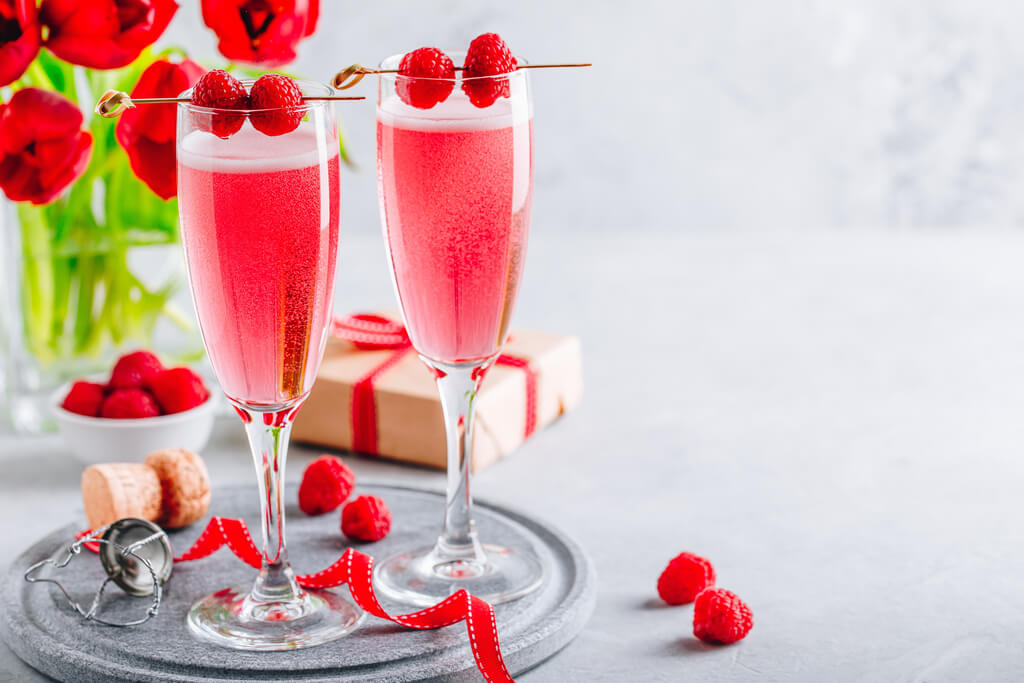 ink cocktail with champagne or prosecco and fresh raspberries for Valentine's day.