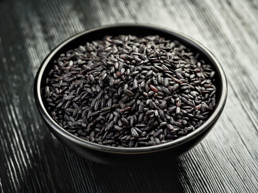 Uncooked black rice in a black bowl