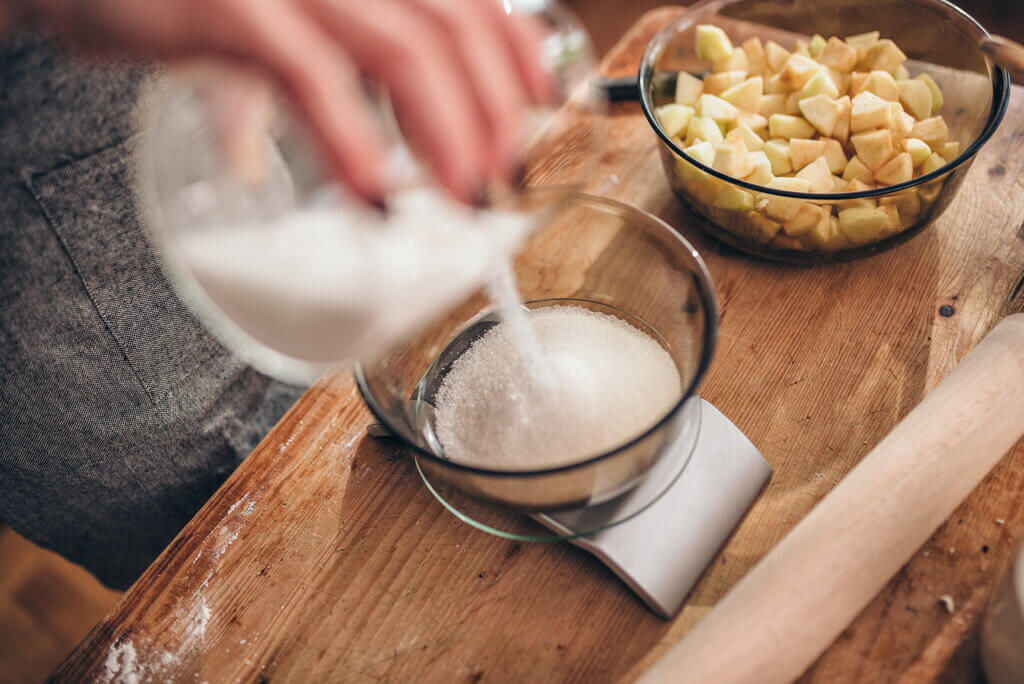 person using measuring scale to measure sugar
