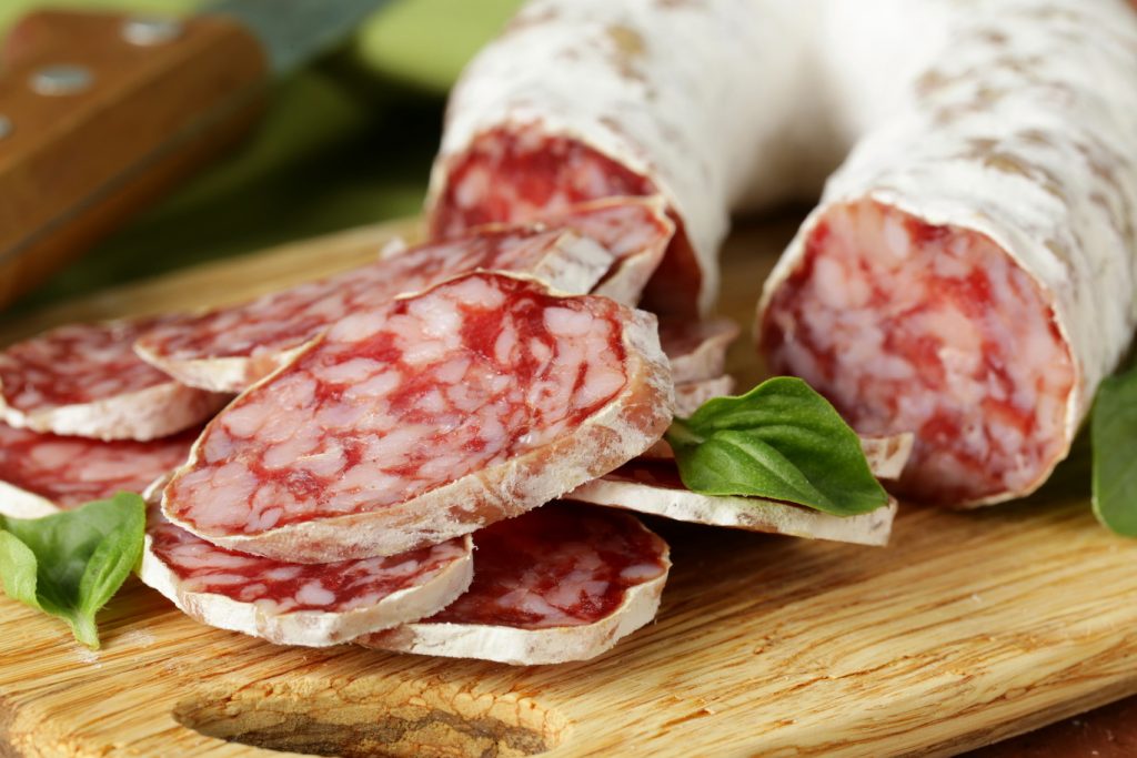 soppressata sliced and placed on a wooden board