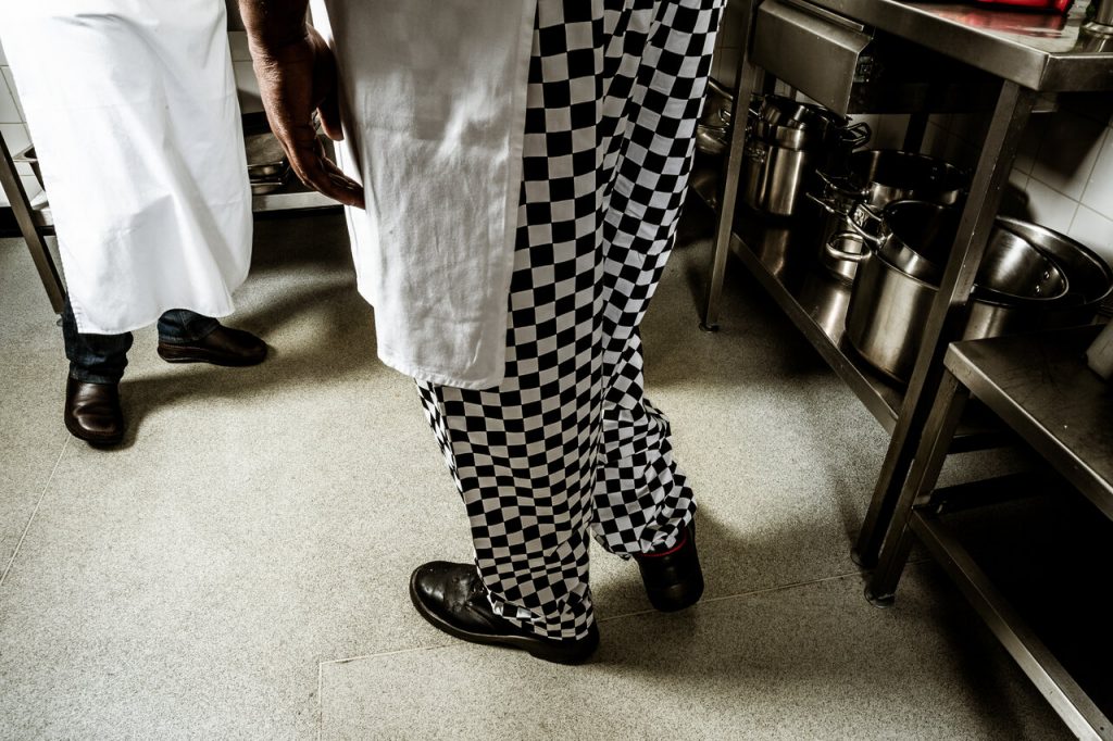 two chefs standing near a kitchen counter wearing kitchen shoes