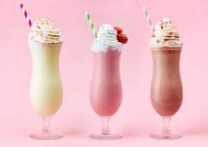 vanilla, strawberry, and chocolate milkshake on pink background, malt vs shake