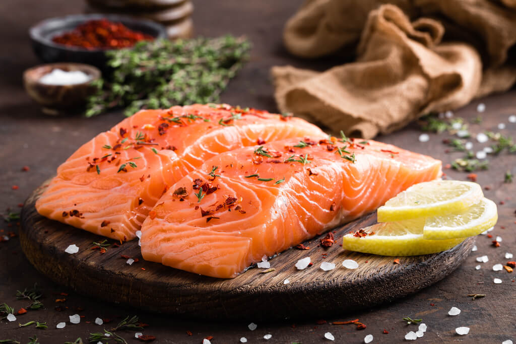 raw salmon fillet on wooden chopping board