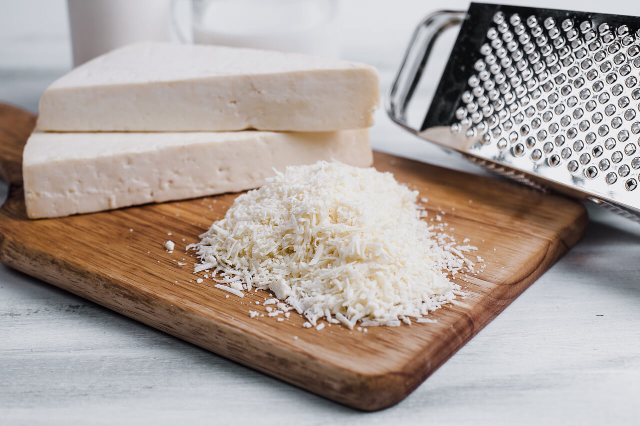 grated cotija cheese on a wooden chopping board