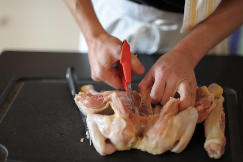 chef popping the breastbone using a sharp knife