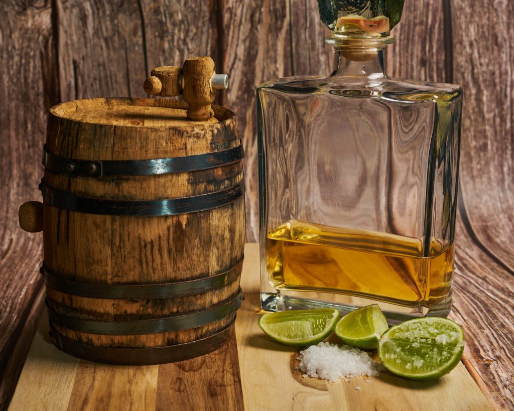 tequila in a barrel and decanter with salt and lime, reposado vs anejo vs blanco