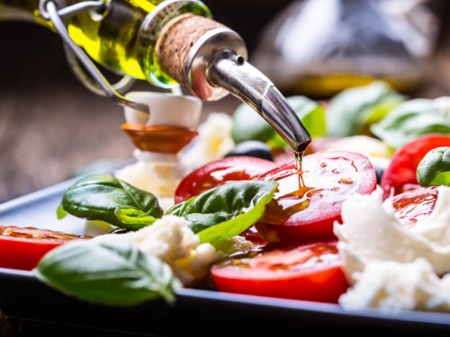 drizzling olive oil on a salad