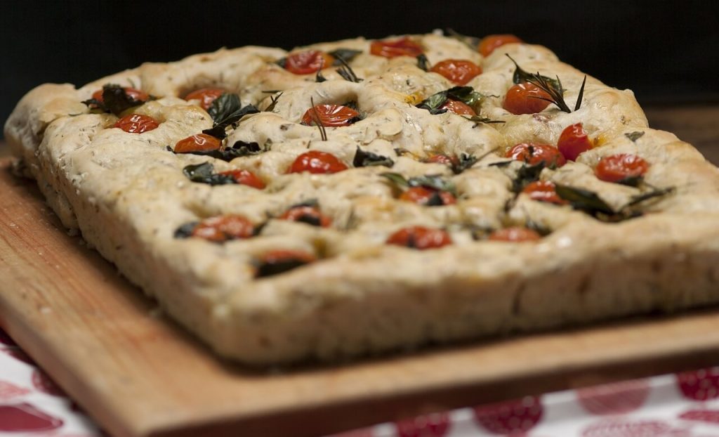 focaccia bread topped with rosemary and cherry tomatoes