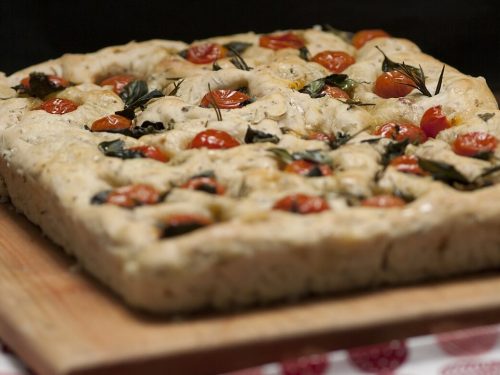 focaccia bread topped with rosemary and cherry tomatoes