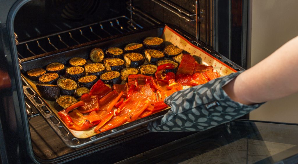 taking out baked veggies from the oven, baked vs broil