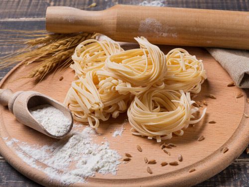 fettuccine noodles on wooden chopping board