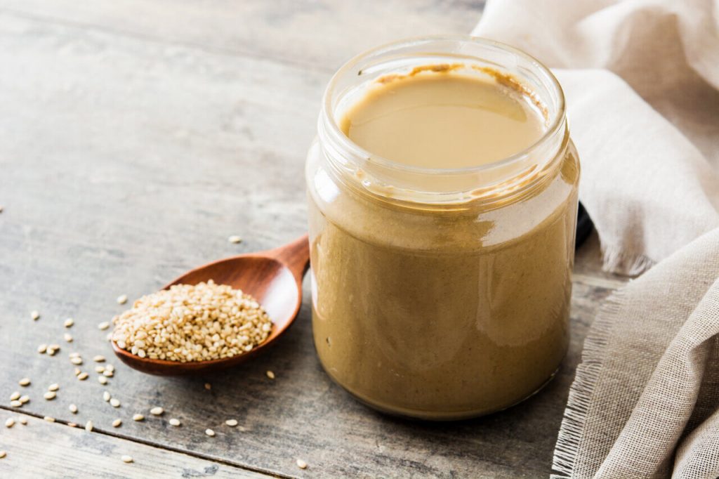 jar of tahini and tablespoon of sesame seeds