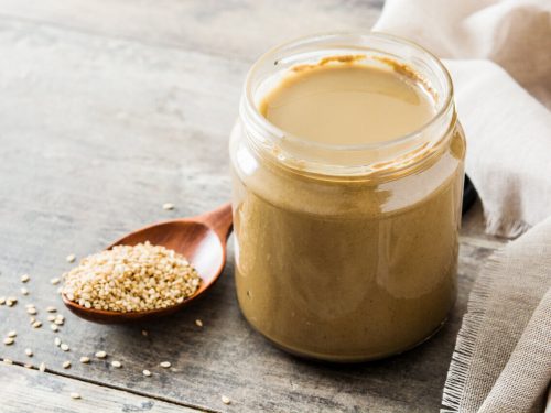 jar of tahini and tablespoon of sesame seeds