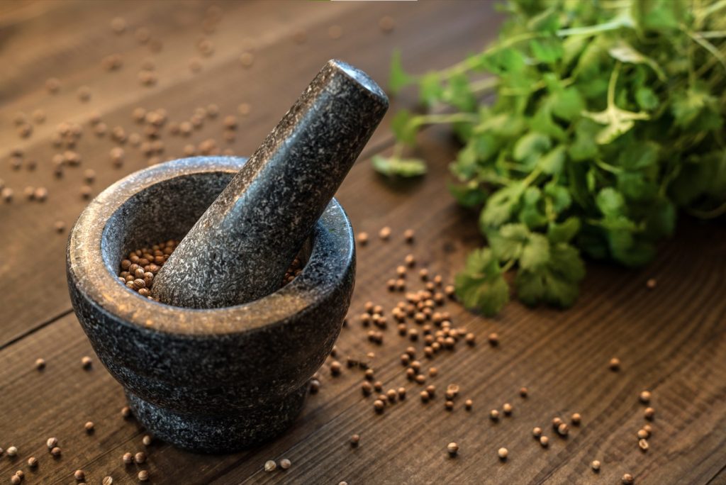 granite mortar and pestle with seeds and herbs