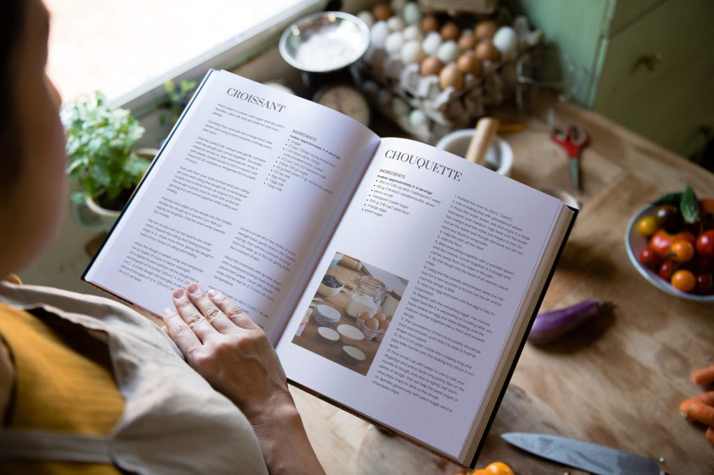 woman holding cookbook, 5 cookbook design ideas