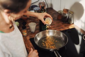 person cooking with stainless steel pan