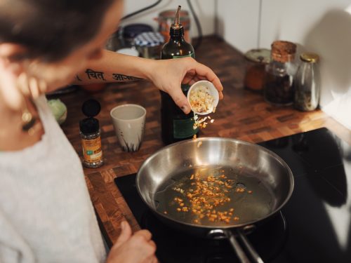 person cooking with stainless steel pan