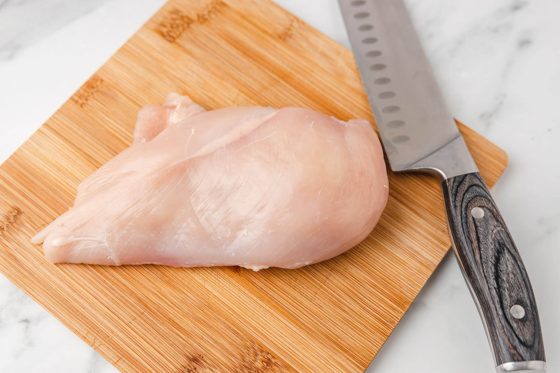 Raw Chicken Cutlets on a Cutting Board: Cutting chicken breasts