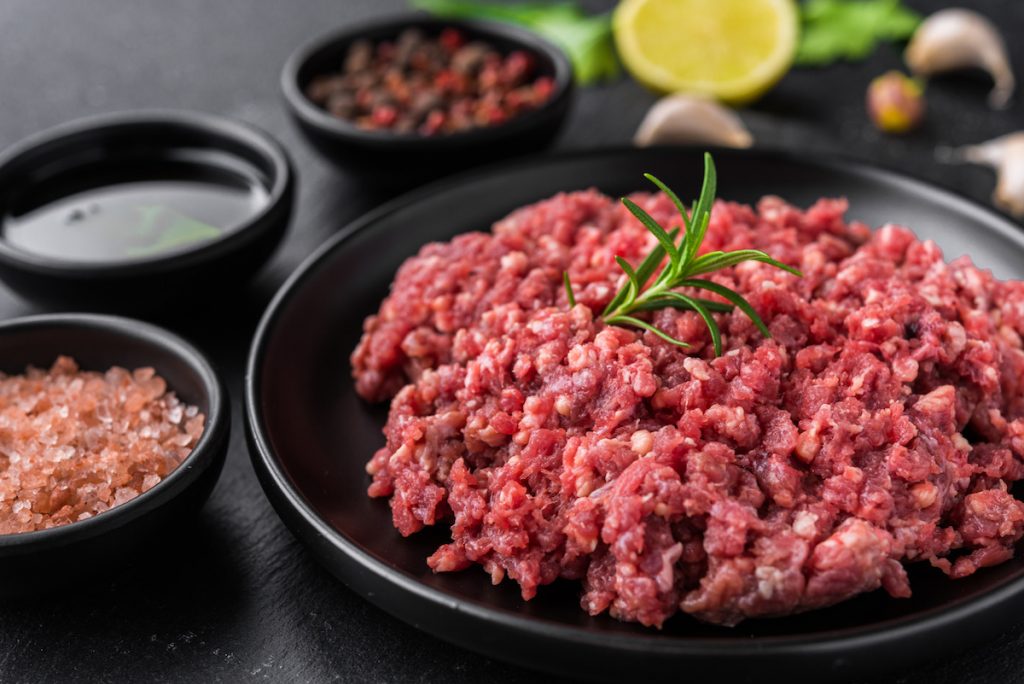 Fresh minced meat ground beef on a black plate