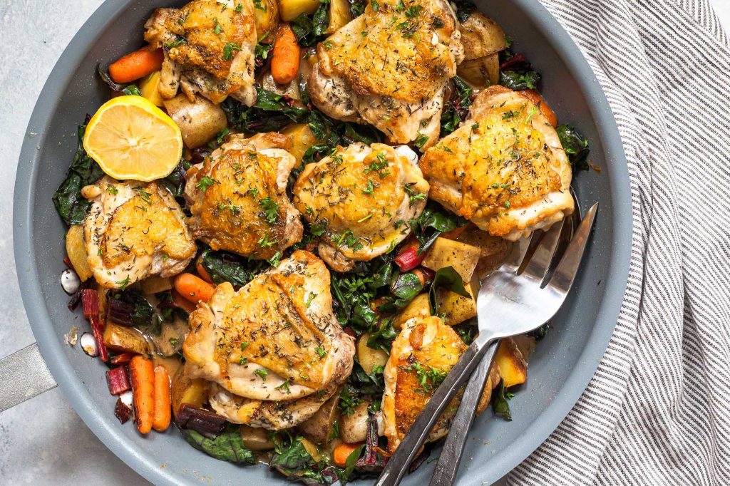 skillet chicken thighs with potatoes, carrots, and greens recipe