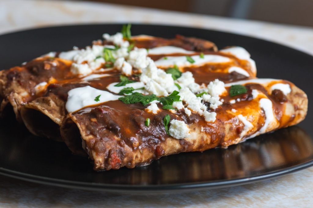 Enfrijoladas Recipe, mexican enfrijoladas with black bean sauce, mexican crema, and queso fresco